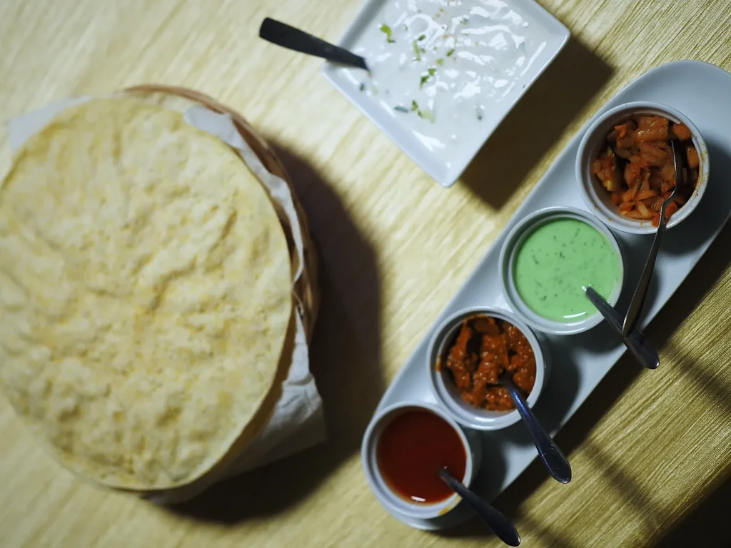 Papadum con raita y chutneys en The Everest Dénia
