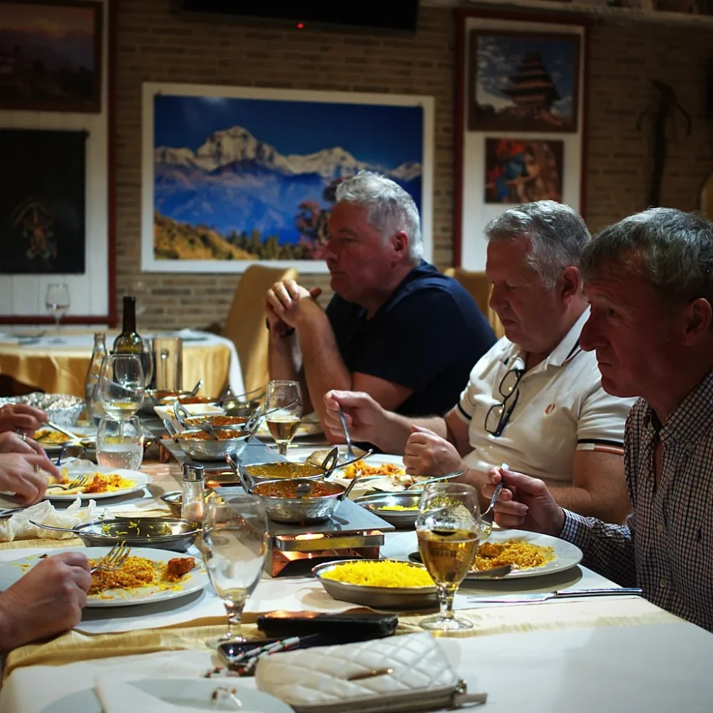 Grupo compartiendo platos indios y nepalíes en el comedor de The Everest Dénia